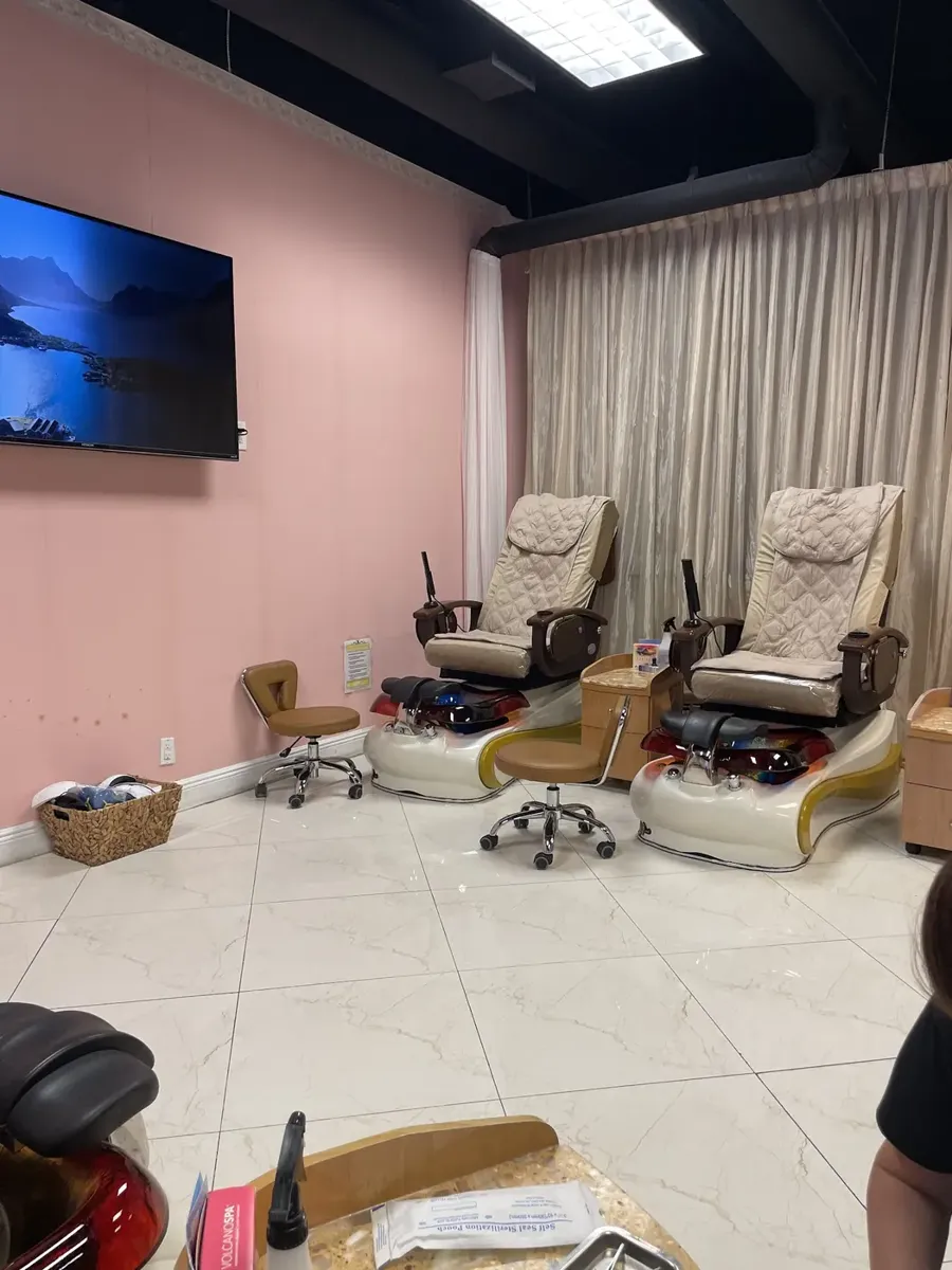 Inside the salon: blush pink walls, cream pedicure spa chairs and marble floors
